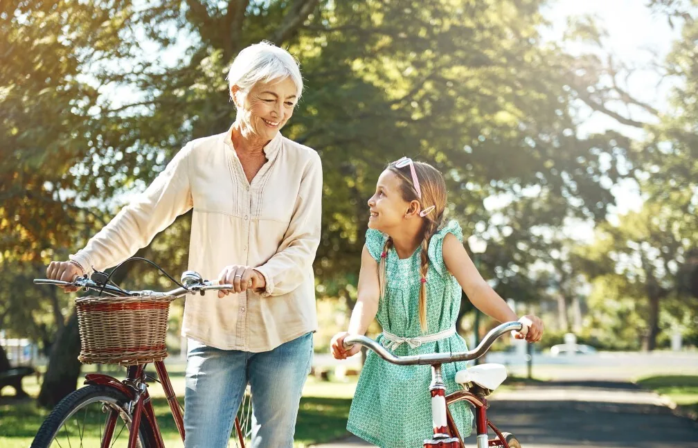 A grandmother riding bikes with her granddaughter