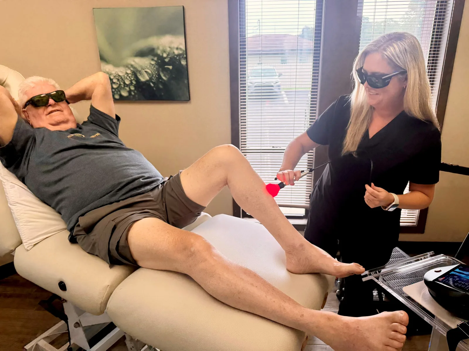 A medical assistant treating a patient with the Class IV laser