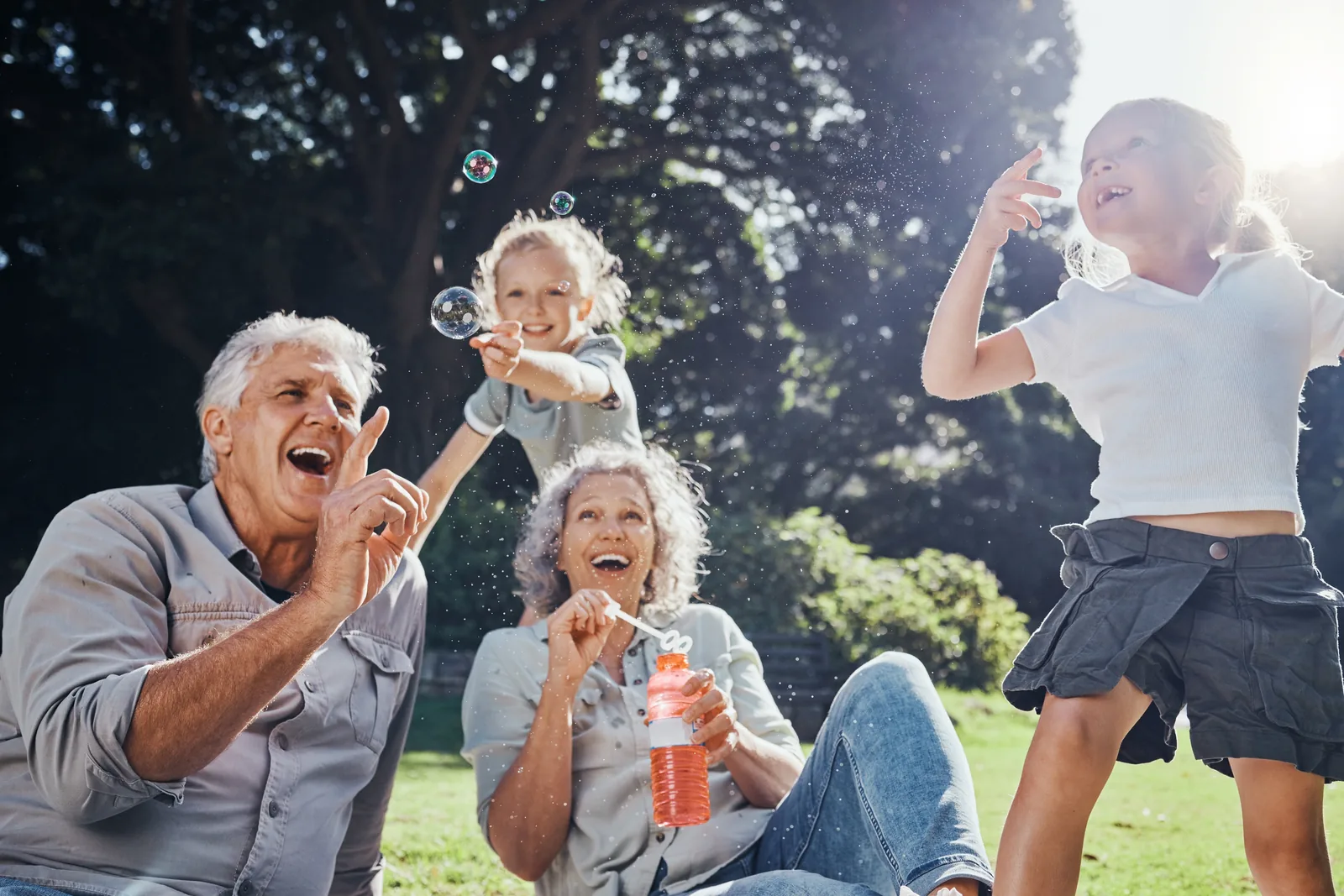 Grandparents laughing with their grandchild outdoors