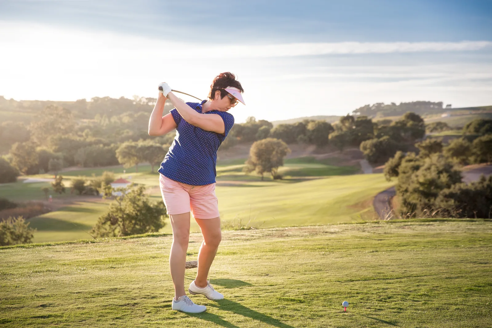 A woman back out on the golf course after treatment